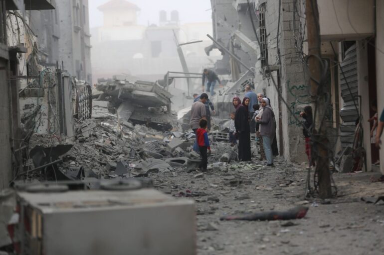 Menschen versammeln sich auf den Trümmern eines zerstörten Gebäudes nach einem Luftangriff im Flüchtlingslager Maghazi im Zentrum des Gazastreifens.