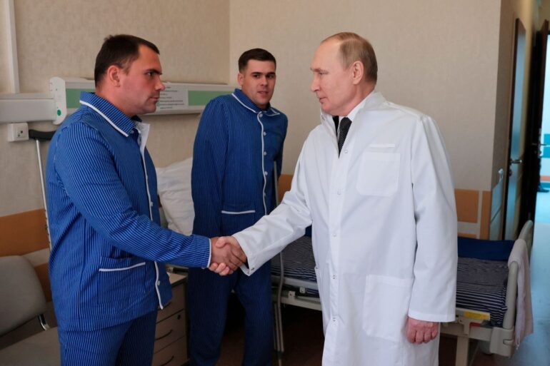 Russlands Präsident Wladimir Putin (r.) während eines Besuchs von verletzten Gefreiten im zentralen Militärkrankenhaus in Moskau.