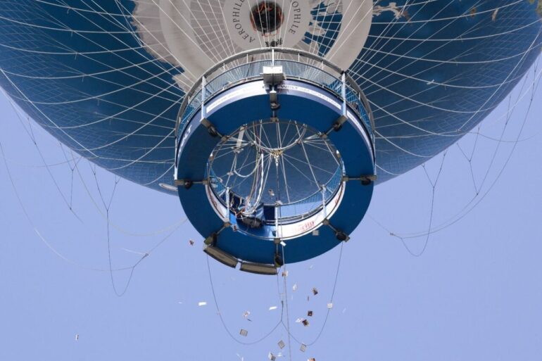 Israelische Angehörige von Hamas-Geiseln werfen Zettel mit Fotos von Geiseln aus einem Heißluftballon in Berlin-Mitte.