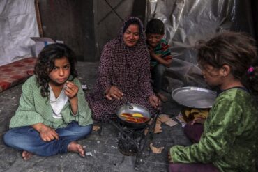 Eine palästinensische Familie kocht in einem behelfsmäßigen Zelt in Rafah.