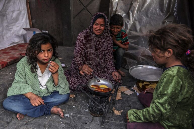 Eine palästinensische Familie kocht in einem behelfsmäßigen Zelt in Rafah.