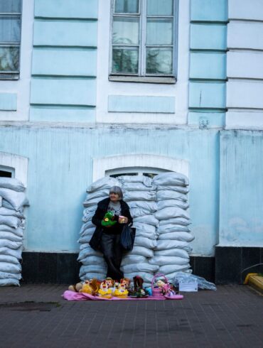 Kiew ist eine Stadt der Gegensätze geworden: Vor mit Sandsäcken geschützten Fenstern verkauft eine Frau Spielzeug. Die Ukraine verteidigt sich nun seit 796 Tagen gegen den russischen Angriffskrieg.