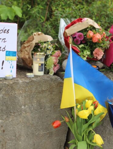 Am Gelände eines Einkaufszentrums, an dem zwei Männer aus der Ukraine getötet worden sind, wurden Blumen niedergelegt sowie eine kleine ukrainische Flagge aufgestellt.