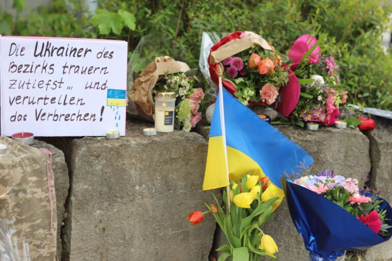 Am Gelände eines Einkaufszentrums, an dem zwei Männer aus der Ukraine getötet worden sind, wurden Blumen niedergelegt sowie eine kleine ukrainische Flagge aufgestellt.