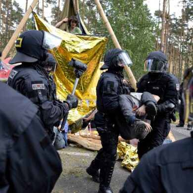 Die Polizei löst eine Straßenblockade auf.