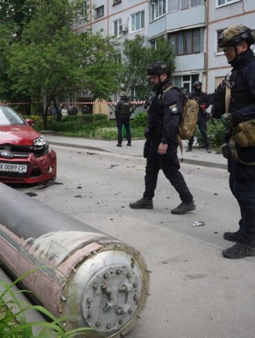 Polizisten inspizieren einen Teil einer russischen Rakete, die in der Nähe eines Wohnhauses in Charkiw eingeschlagen ist.