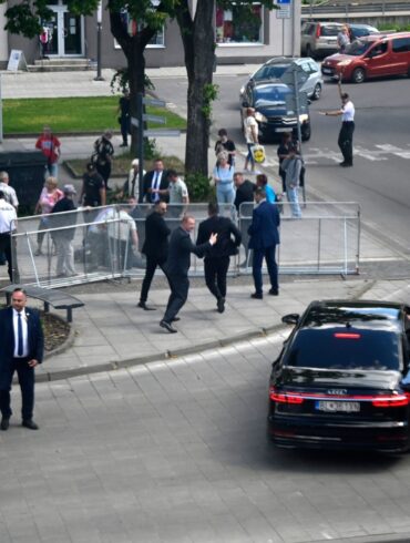 Leibwächter bringen den slowakischen Ministerpräsidenten Robert Fico in einem Auto vom Ort des Geschehens in Sicherheit.