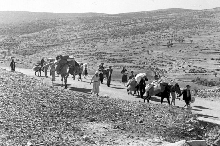 Arabische Flüchtlinge gehen mit ihren Kindern und Habseligkeiten im Gepäck am 9. November 1948 auf einer staubigen Straße von Jerusalem in den Libanon. Die Staatsgründung Israels war 1948 für Hunderttausende von Palästinensern mit Vertreibung und dem Verlust von Heimat verbunden.