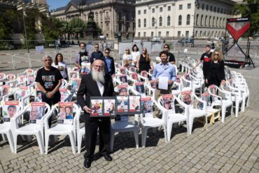 Angehöre von Geiseln und Teilnehmer der Veranstaltung stehen auf dem Beblplatz. Der Bebelplatz soll für einige Wochen symbolisch zum «Platz der Hamas-Geiseln» werden. Es wurden auch 132 leere Stühle aufgestellt.