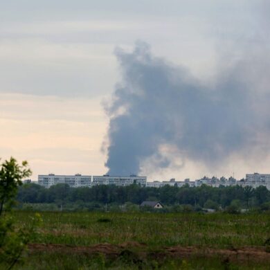 Nach dem Beschuss durch russische Truppen steigt eine Rauchsäule hinter Wohnhäusern in Charkiw auf.