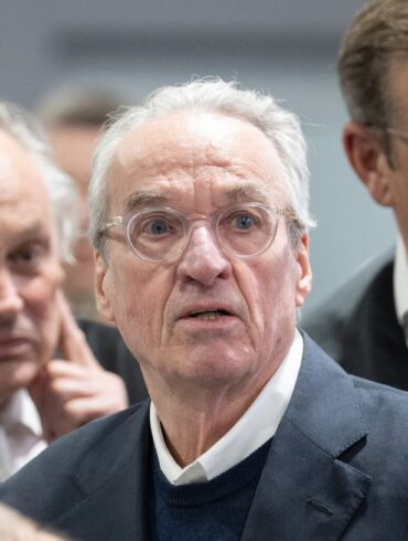 Zum Prozessauftakt gegen die mutmaßliche «Reichsbürger»-Gruppe steht der Hauptangeklagte Heinrich XIII. Prinz Reuß (M) zwischen seinen Verteidigern im Gerichtssaal.