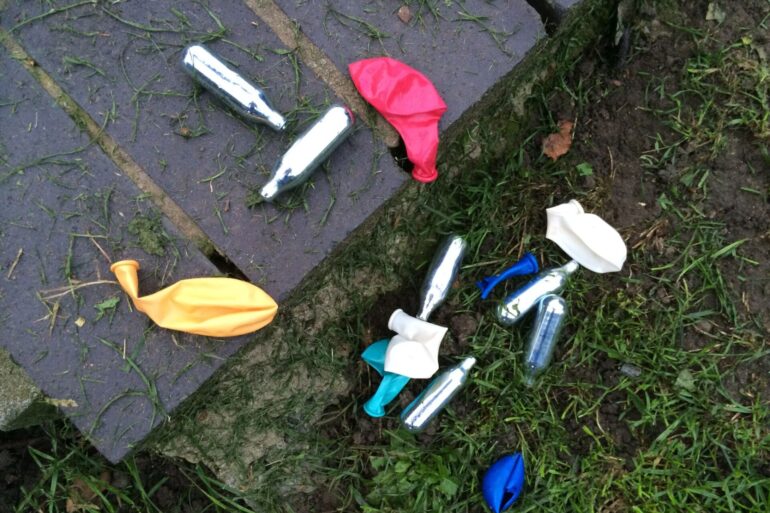 Rausch mit Folgen: Lachgas-Kartuschen und Luftballons in einem Park.