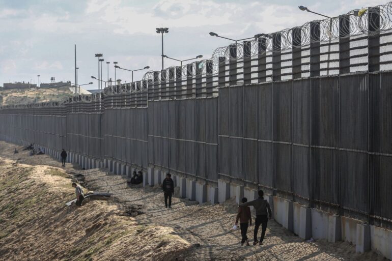 Palästinenser stehen nahe der Grenze zwischen dem Gazastreifen und Ägypten (Archivbild).