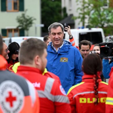 Bayerns Ministerpräsident Markus Söder (M, CSU), spricht zu Einsatzkräften vom Roten Kreuz, DLRG und anderen Rettungskräften bei einer Ortsbesichtigung im vom Hochwasser betroffenen oberbayerischen Reichertshofen.