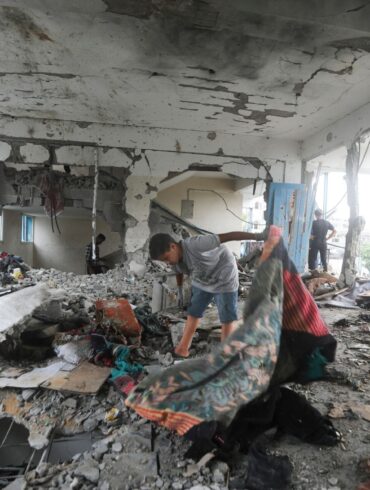 Palästinenser nehmen in einer vom UN-Palästinenserhilfswerk UNRWA betriebenen Schule die Folgen des israelischen Angriffs  in Augenschein.