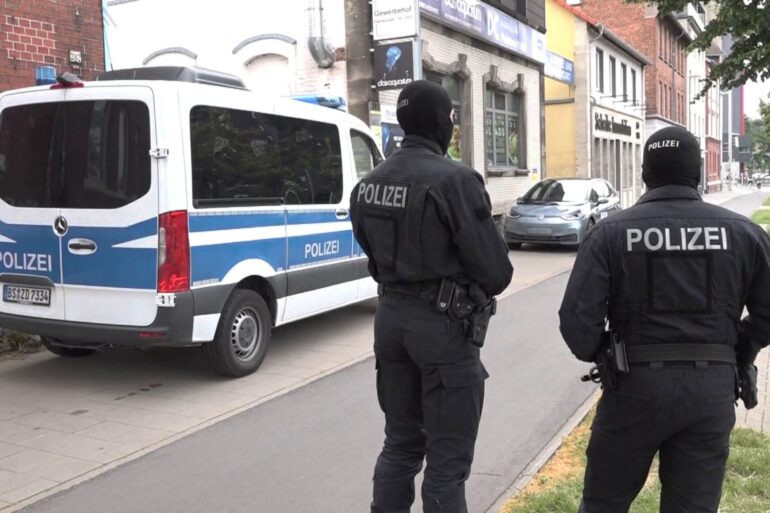 Polizeibeamte vor einem der durchsuchten Objekte in Braunschweig.