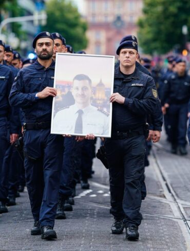 In Gedenken an ihren tödlich verletzten Kollegen Rouven Laur ziehen Polizisten durch die Mannheimer Innenstadt.