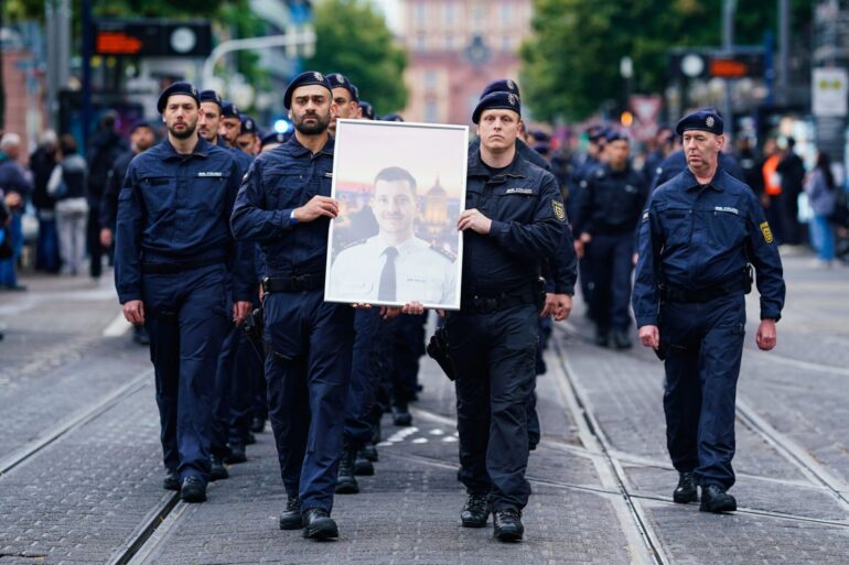 In Gedenken an ihren tödlich verletzten Kollegen Rouven Laur ziehen Polizisten durch die Mannheimer Innenstadt.