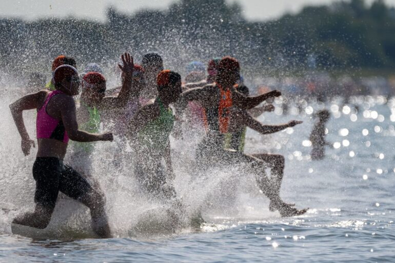 Rettungsschwimmer laufen ins Wasser: Rund 190 Rettungsschwimmer aus fünf Ländern nehmen an dem Finale in der Disziplin "Oceanman" in Warnemünde teil.