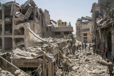 In der Stadt Gaza stehen Palästinenser inmitten zerstörter Gebäude