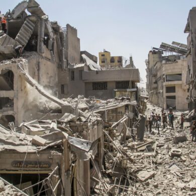 In der Stadt Gaza stehen Palästinenser inmitten zerstörter Gebäude