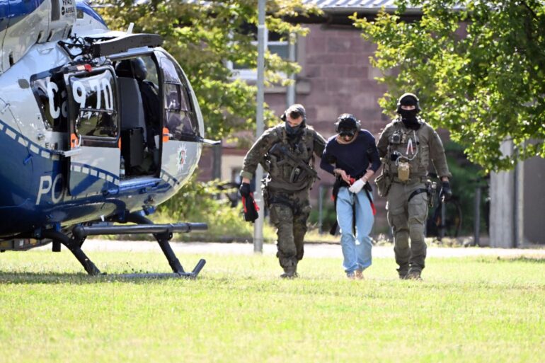 Der Tatverdächtliche wurde in Karlsruhe von bewaffneten Polizisten in Spezialausrüstung vom Helikopter zu einer Wagenkolonne gebracht.
