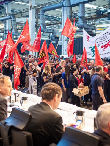 Auf der Betriebsversammlung in Wolfsburg begrüßen Mitarbeiter den Vorstand mit scharfem Protest gegen die jüngsten Sparpläne.