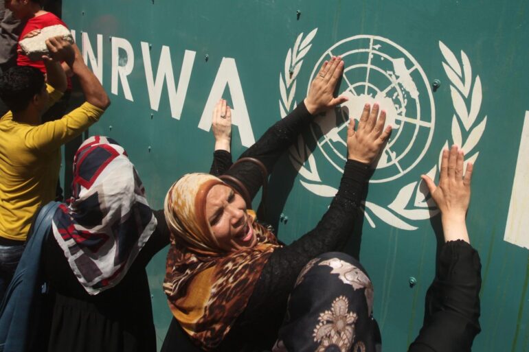 Palästinenserinnen vor UNRWA-Schild (Archivbild)