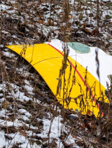 Auf einem Trümmerteil des abgestürzten Flugzeugs sind die DHL-Farben zu sehen.
