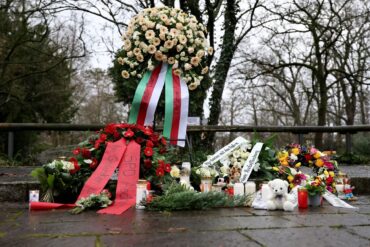 Menschen haben Blumen niedergelegt.