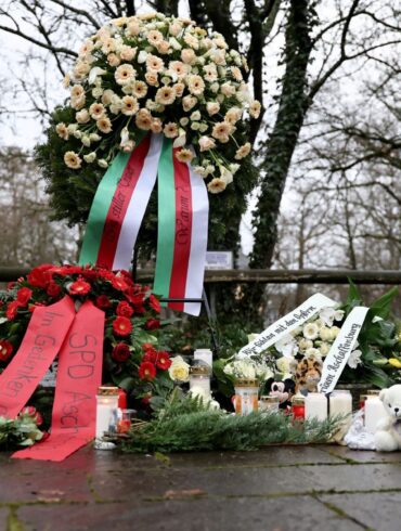 Menschen haben Blumen niedergelegt.