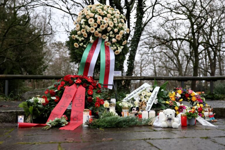 Menschen haben Blumen niedergelegt.