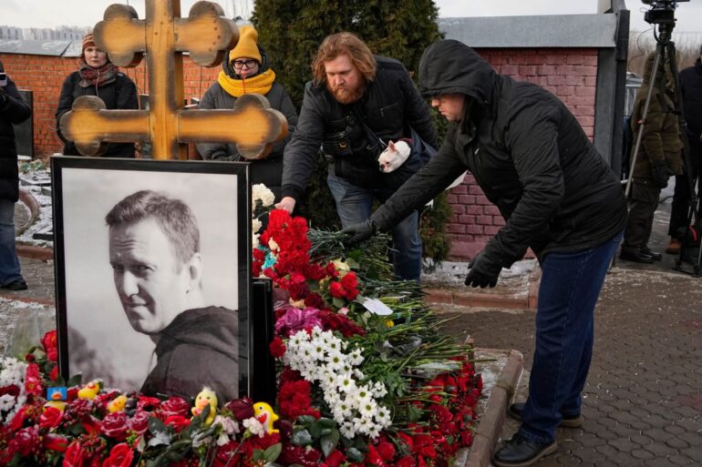 Menschen legen ein Jahr nach dem Tod des russischen Oppositionsführers Alexej Nawalny auf dem Borisowskoje-Friedhof in Moskau Blumen an seinem Grab nieder.