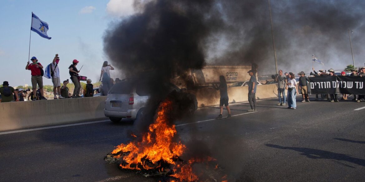 Israelische Demonstranten blockieren eine Straße bei einem Protest.