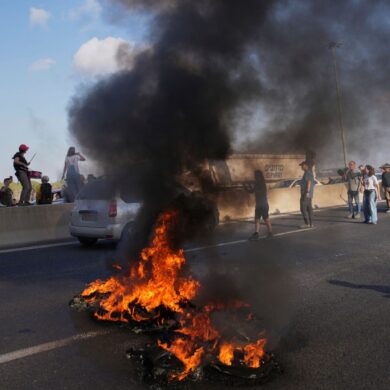 Israelische Demonstranten blockieren eine Straße bei einem Protest.