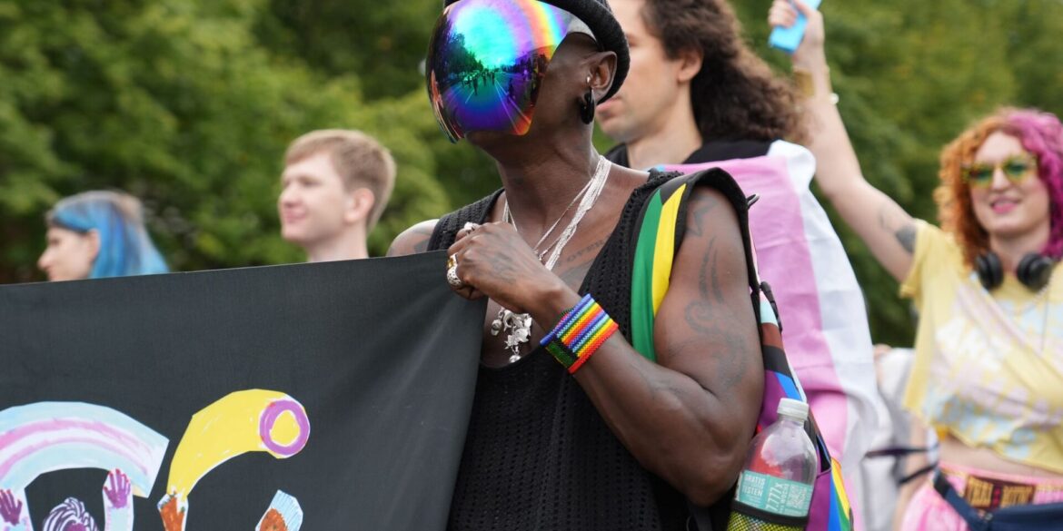 Pride-Demo: Ein Teilnehmer trägt ein bunt schillerndes Visier bei einer Demonstration in Berlin unter dem Motto: "Inta* Pride Berlin 2025 - we exist!".