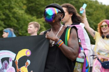 Pride-Demo: Ein Teilnehmer trägt ein bunt schillerndes Visier bei einer Demonstration in Berlin unter dem Motto: "Inta* Pride Berlin 2025 - we exist!".