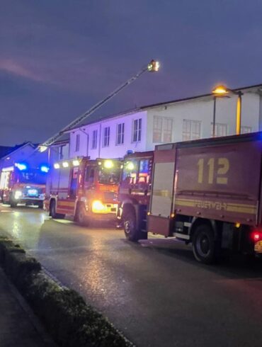 Feuerwehrfahrzeuge stehen vor dem Supermarkt.