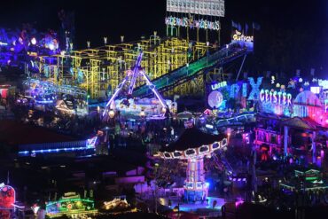 Fahrgeschäfte leuchten auf dem Oktoberfest.