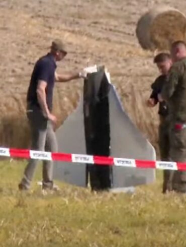 Einsatzkräfte von Polizei und Militärpolizei sichern Teile einer beschädigten Drohne.