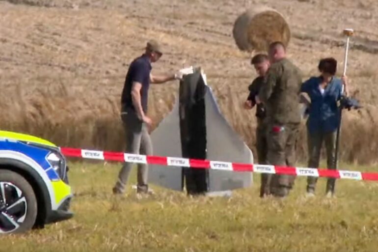 Einsatzkräfte von Polizei und Militärpolizei sichern Teile einer beschädigten Drohne.