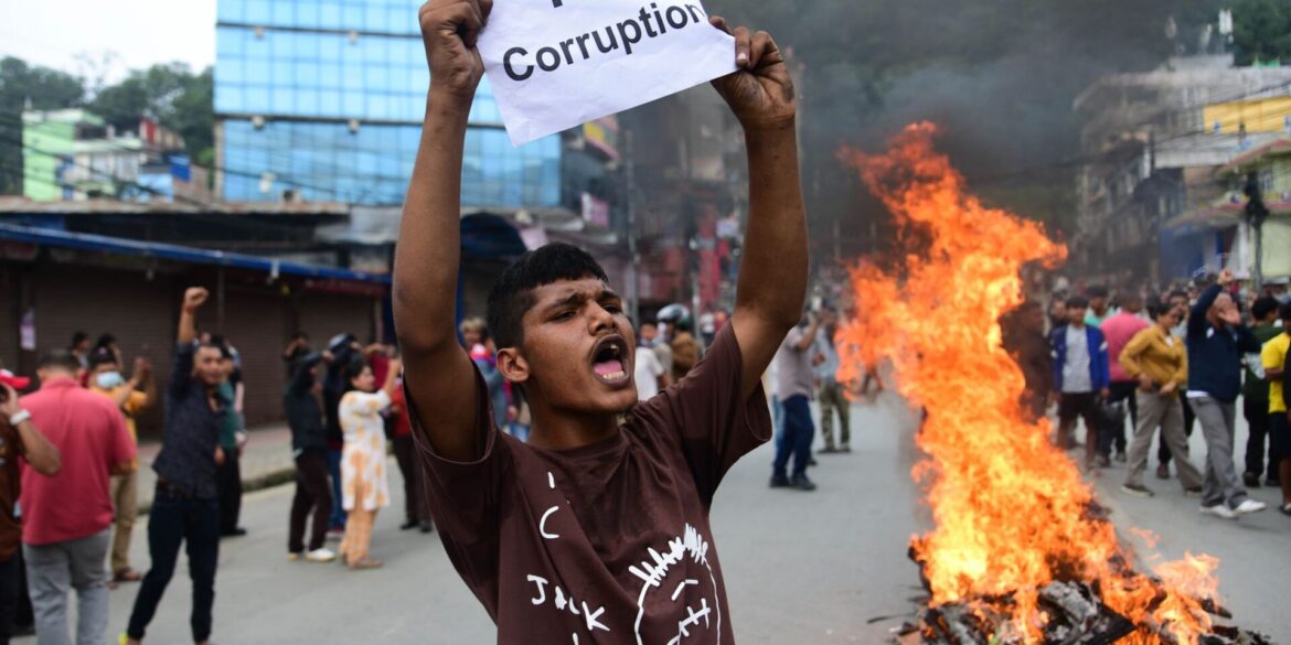Ein Demonstrant in Nepal hält ein Blatt mit der Forderung nach einem Ende der Korruption hoch.