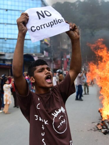Ein Demonstrant in Nepal hält ein Blatt mit der Forderung nach einem Ende der Korruption hoch.