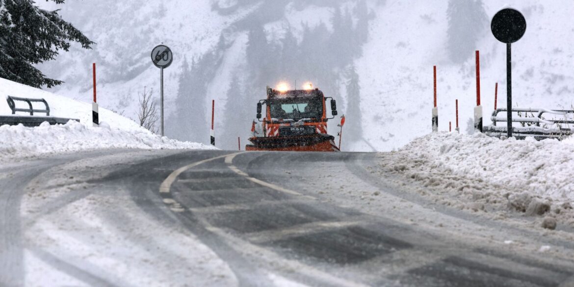Ein Räumfahrzeug des Winterdienstes fährt auf dem Riedbergpass im Schneetreiben.