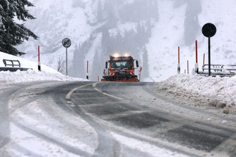 Ein Räumfahrzeug des Winterdienstes fährt auf dem Riedbergpass im Schneetreiben.