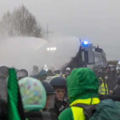 Die Polizei setzt Wasserwerfer gegen Demonstranten ein, die die B429 nahe der Lahnbrücke blockieren.
