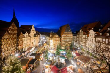 Lichter leuchten auf dem Hildesheimer Weihnachtsmarkt auf dem historischen Marktplatz mit dem Knochenhaueramtshaus.