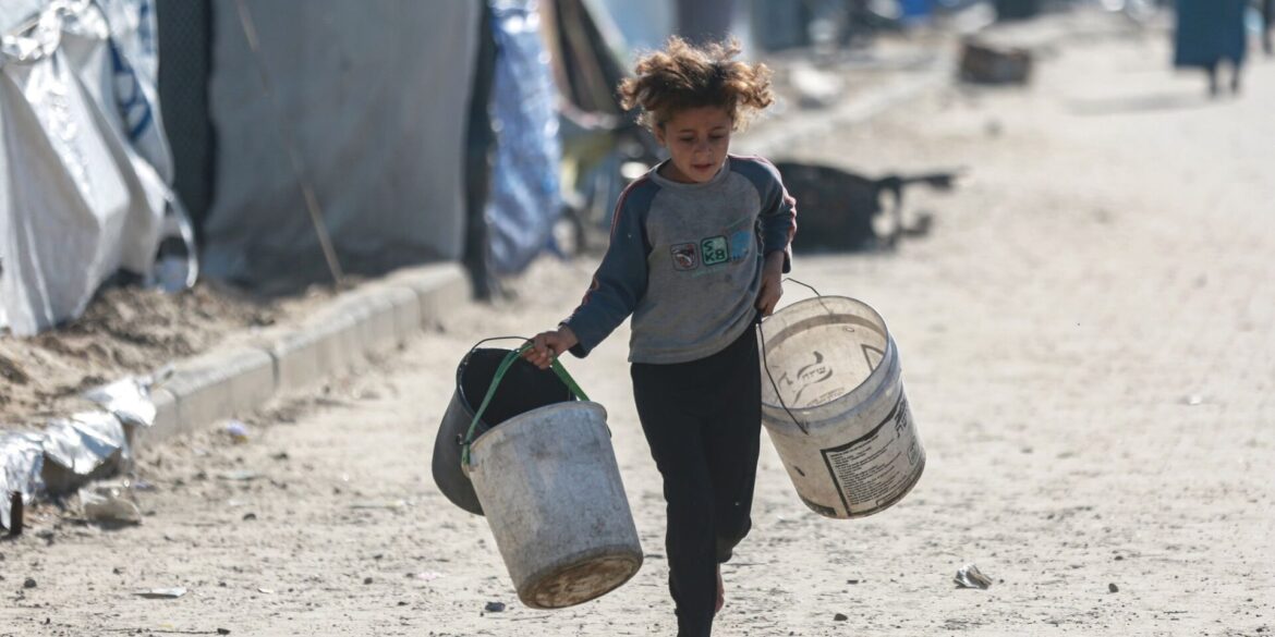 Wasser wird zum Luxus: Kind rennt mit leeren Eimern zu einer Wasserstelle in Gaza