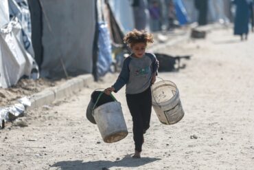 Wasser wird zum Luxus: Kind rennt mit leeren Eimern zu einer Wasserstelle in Gaza