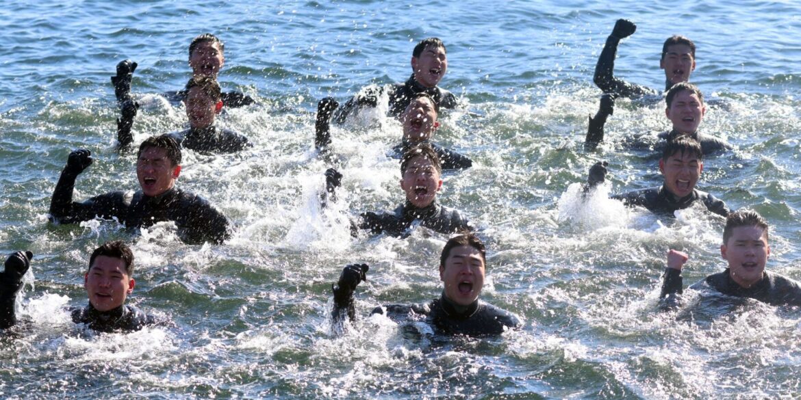 Bei Minusgraden singen Taucher der südkoreanischen Marine, während sie im eiskalten Meerwasser vor der Stadt Changwon schwimmen.